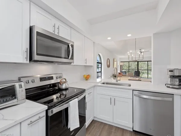 a kitchen with white cabinets stainless steel appliances and sink