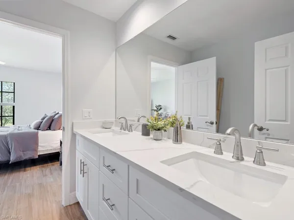 a en suite bathroom with a double vanity sink and a mirror
