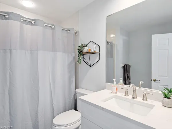 a bathroom with a sink vanity mirror and toilet