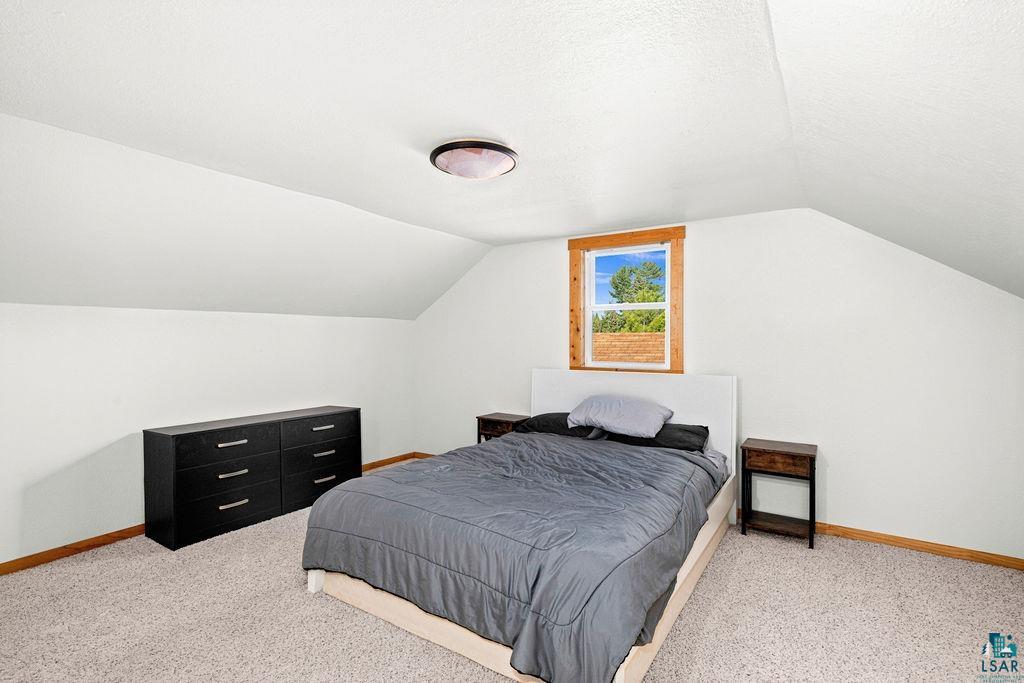 3949 East County Rd B Superior, WI 54880 - Photo 34 of 50 Carpeted flooring, vaulted ceiling, and a framed window