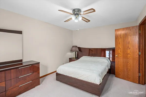 a bedroom with a bed and a ceiling fan