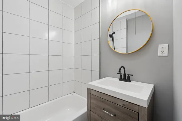 a bathroom with a sink a mirror and a shower