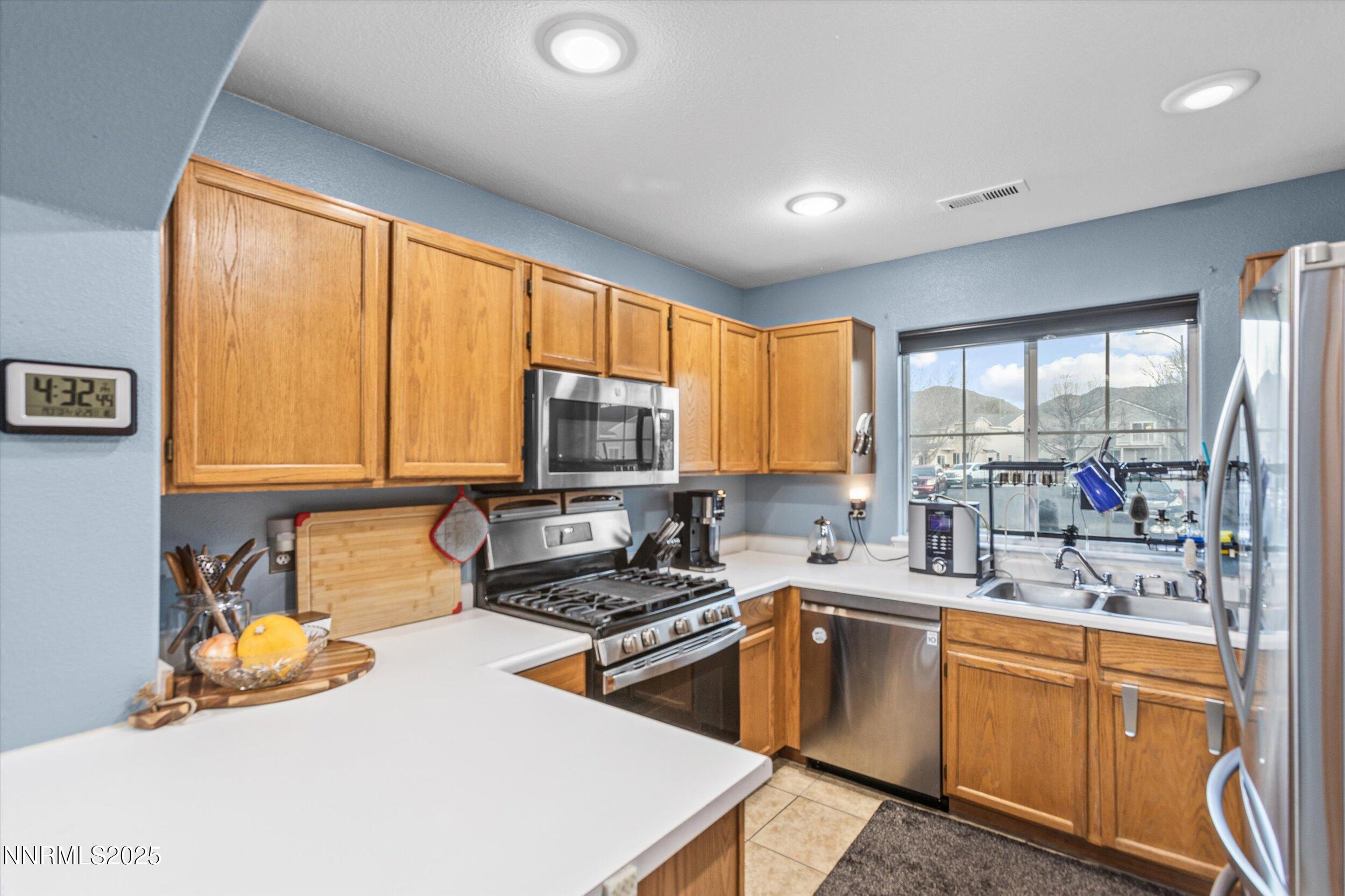 3131 Winter Rose Circle Reno, NV 89502 - Photo 6 of 32 a kitchen with a sink a stove and a refrigerator
