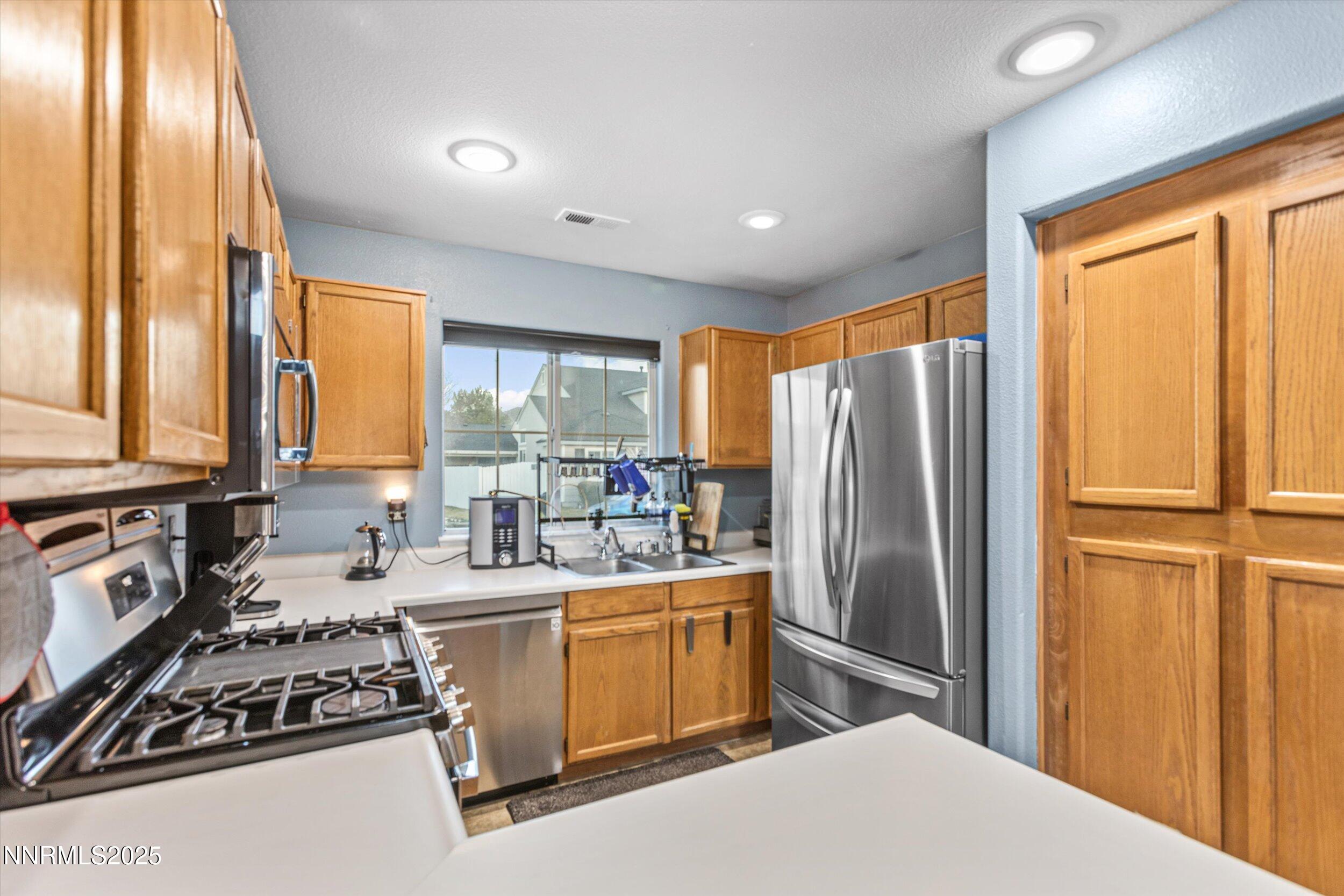 3131 Winter Rose Circle Reno, NV 89502 - Photo 8 of 32 a kitchen with a window a sink and a refrigerator