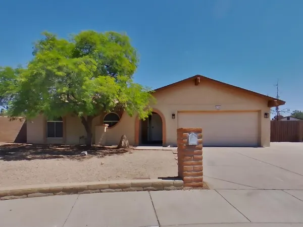 a view of house with yard and tree in front of it