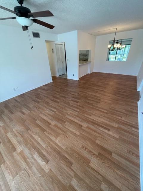 610 Sea Pine Way, Unit A2 Greenacres, FL 33415 - Photo 11 of 13 a view of a big room with wooden floor and chandelier