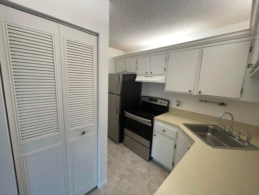 610 Sea Pine Way, Unit A2 Greenacres, FL 33415 - Photo 3 of 13 a kitchen with a sink and white cabinets