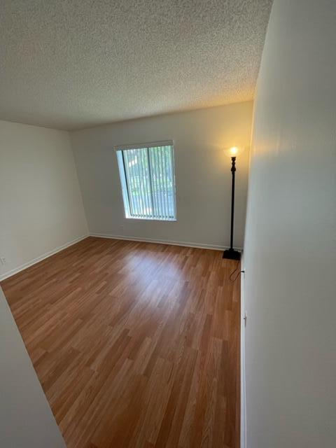 610 Sea Pine Way, Unit A2 Greenacres, FL 33415 - Photo 6 of 13 an empty room with wooden floor cabinet and windows