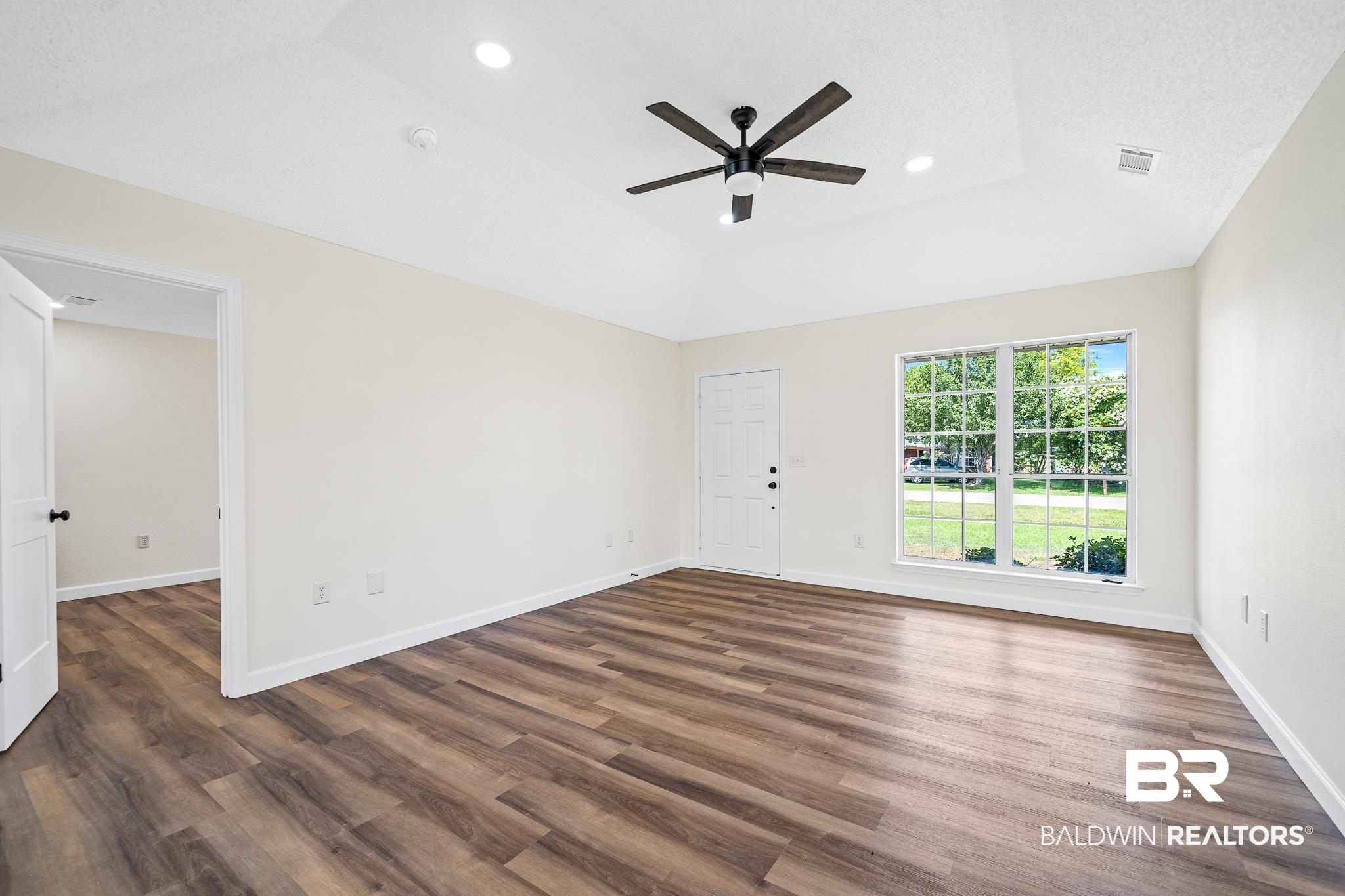 8921 Sherman Road Foley, AL 36535 - Photo 5 of 19 Unfurnished room with a tray ceiling, dark hardwood / wood-style floors, and ceiling fan