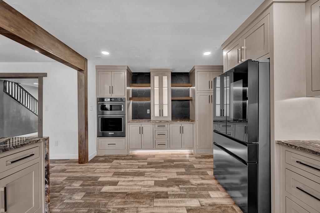 6117 Gainsborough Road Amarillo, TX 79106 - Photo 11 of 40 a kitchen with stainless steel appliances kitchen island granite countertop a refrigerator and a stove top oven