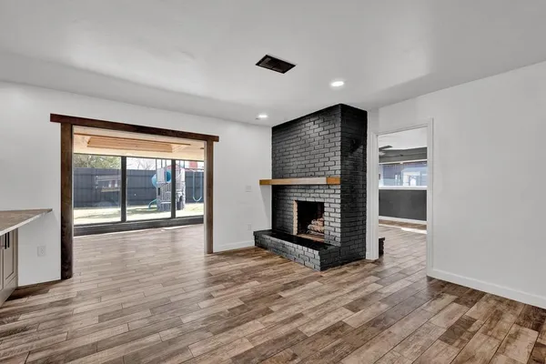 a view of an empty room with a fireplace and a window