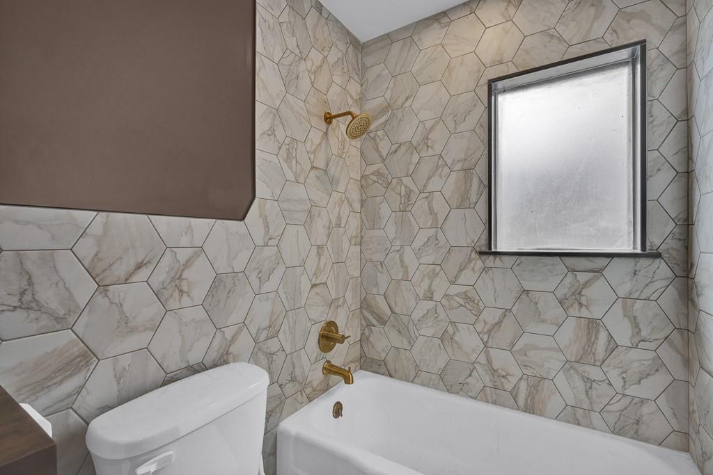 6117 Gainsborough Road Amarillo, TX 79106 - Photo 30 of 40 a bathroom with a toilet and a bathtub