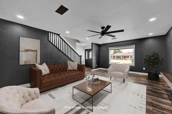 a living room with furniture and a ceiling fan