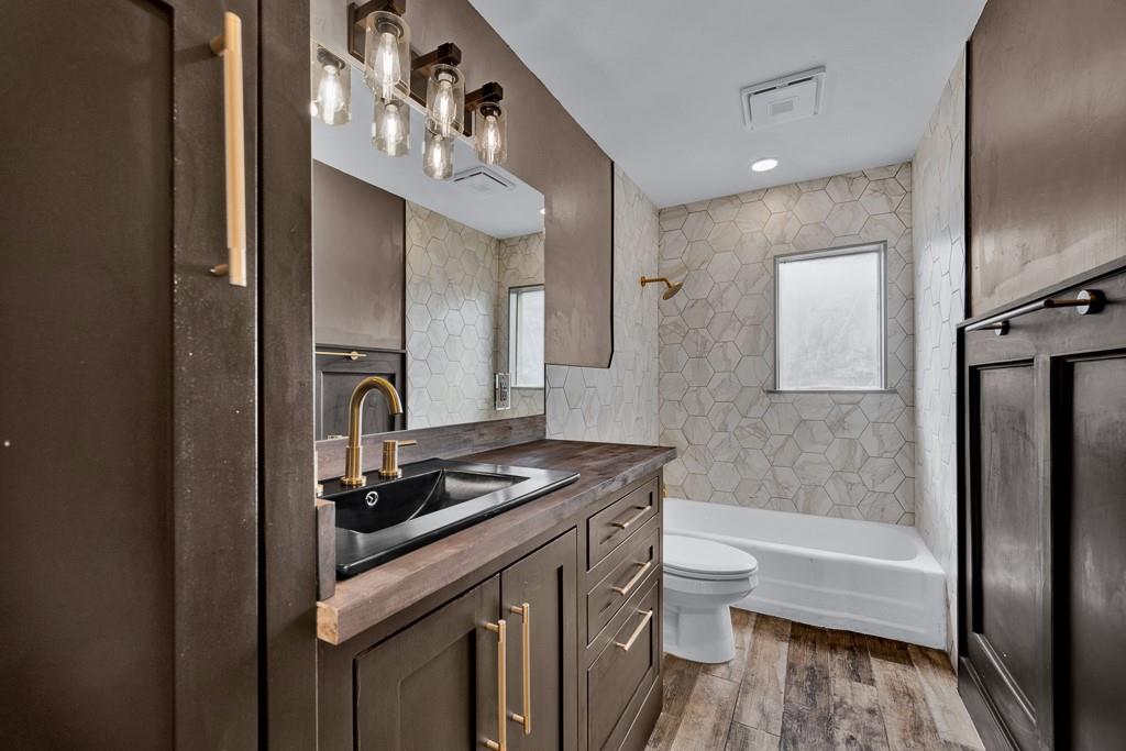 6117 Gainsborough Road Amarillo, TX 79106 - Photo 31 of 40 a bathroom with a granite countertop sink a toilet a mirror and shower