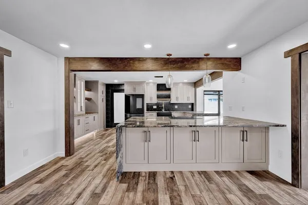 a kitchen with stainless steel appliances kitchen island granite countertop a refrigerator and a stove top oven