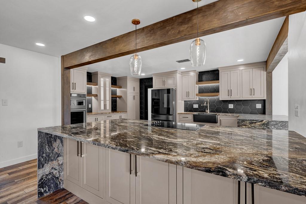 6117 Gainsborough Road Amarillo, TX 79106 - Photo 10 of 40 a kitchen with stainless steel appliances granite countertop a sink stove and refrigerator
