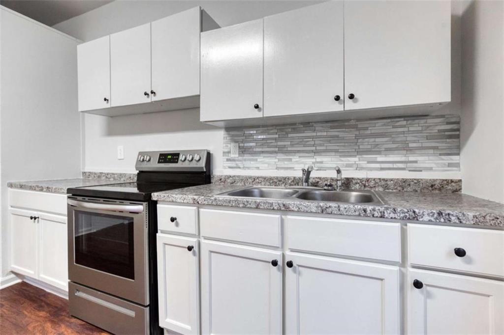 126 6th Street Monroe, GA 30655 - Photo 18 of 24 a kitchen with granite countertop white cabinets and white appliances
