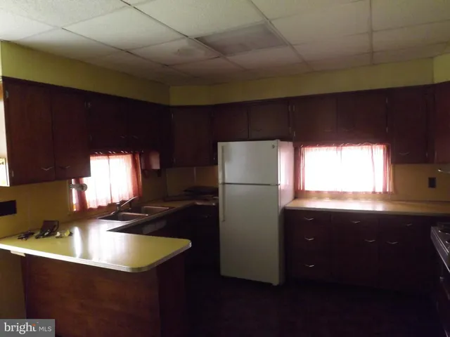 a kitchen with a sink a refrigerator and window