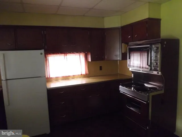 a kitchen with a refrigerator and a stove top oven