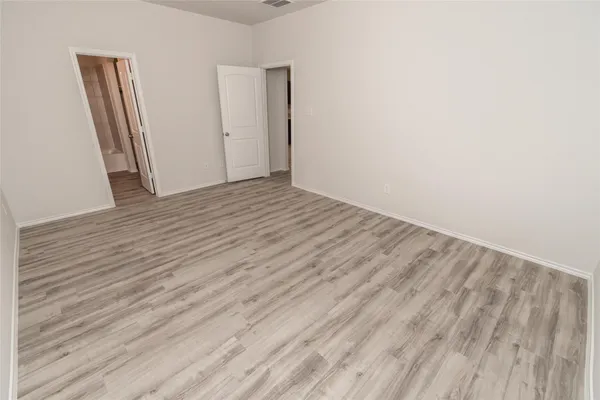 wooden floor in a hall with an empty room