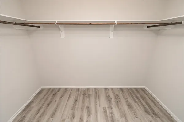 a view of walk in closet with empty racks