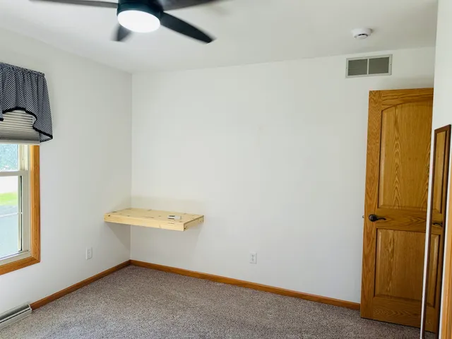 an empty room with wooden floor and a window