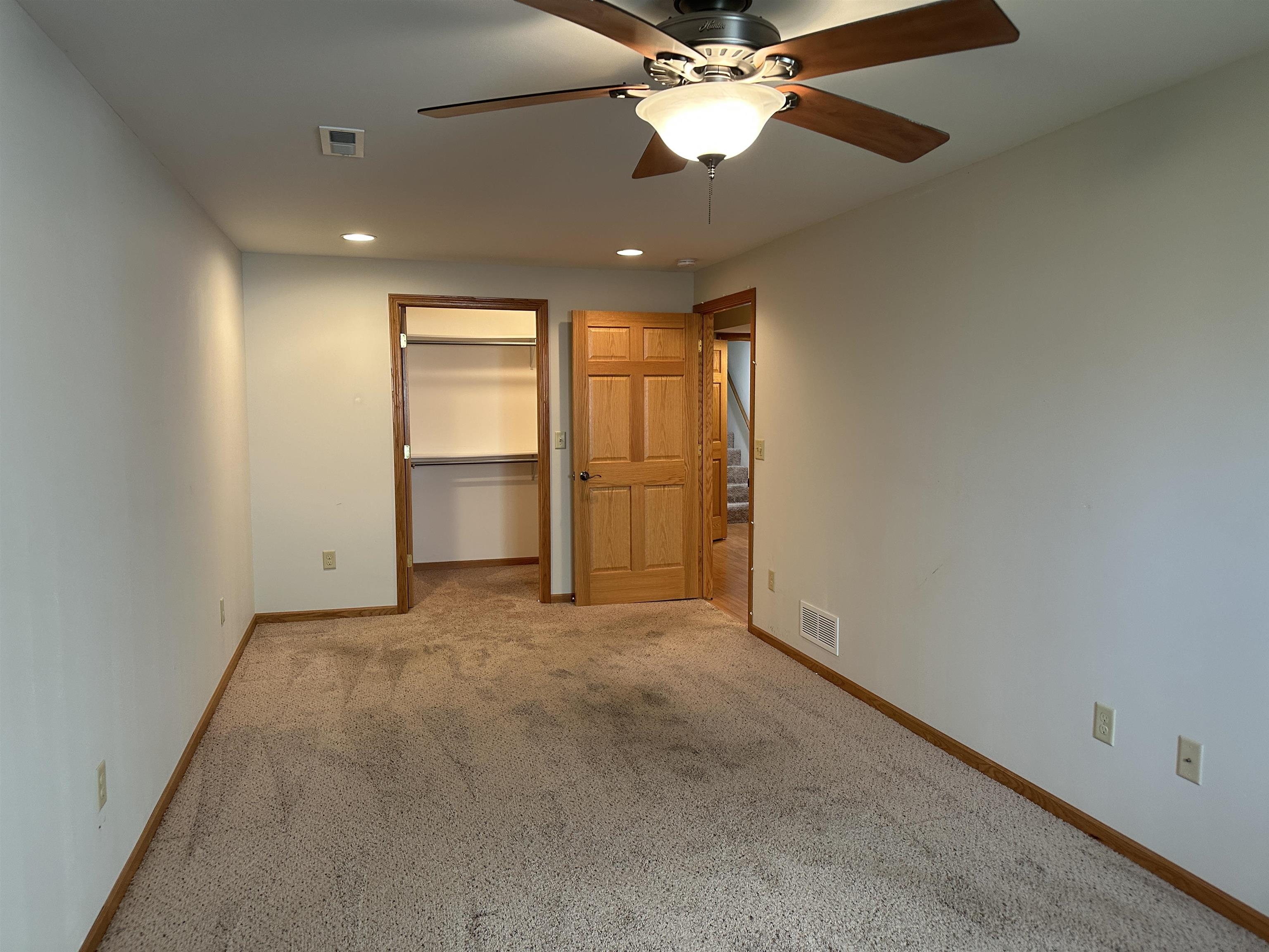 219 Palm Drive Lena, IL 61048 - Photo 39 of 49 an empty room with a ceiling fan and a window