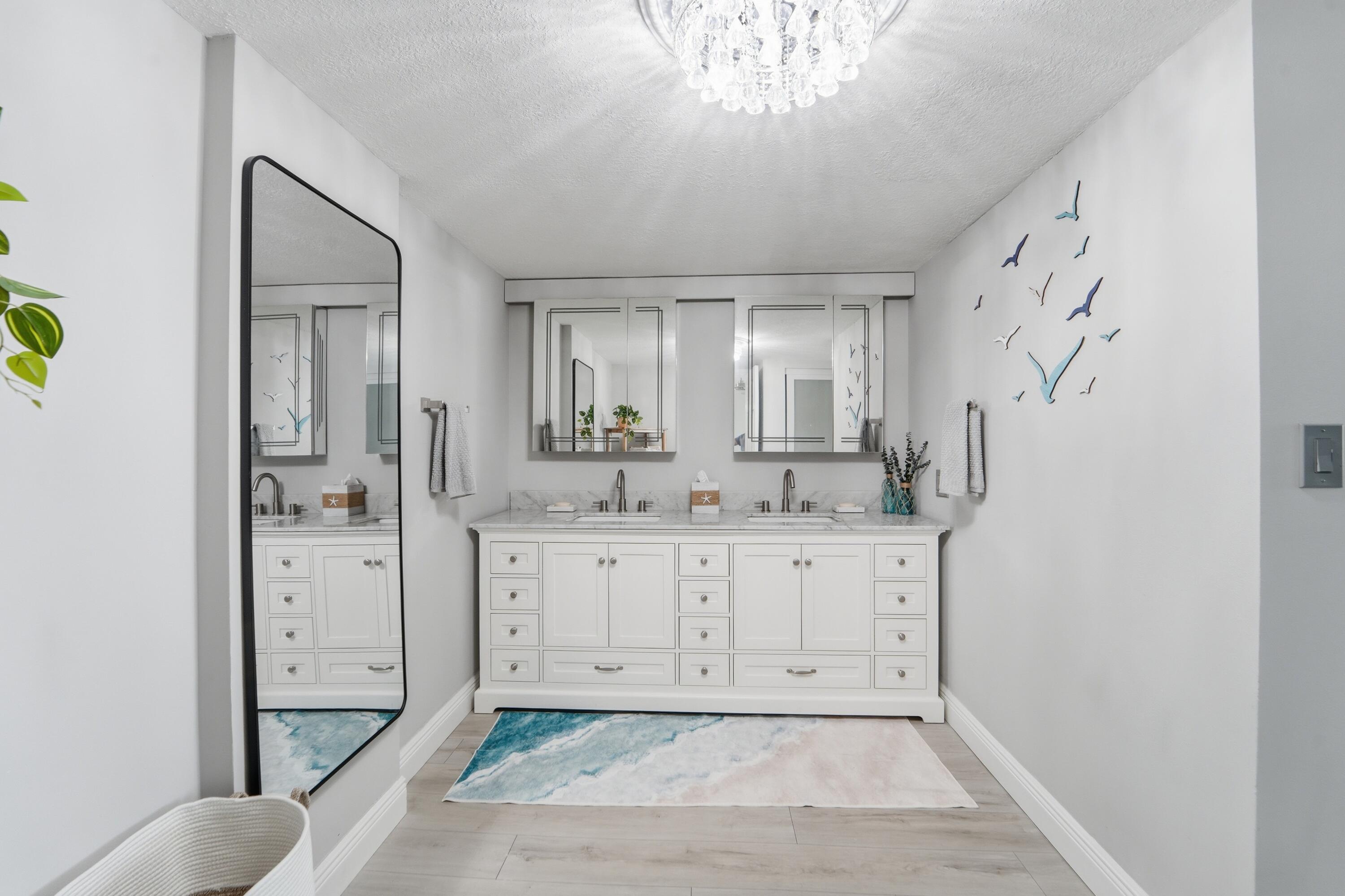 1605 Highway 1, Unit 303M1 Jupiter, FL 33477 - Photo 16 of 42 a spacious bathroom with a granite countertop sink mirror and vanity