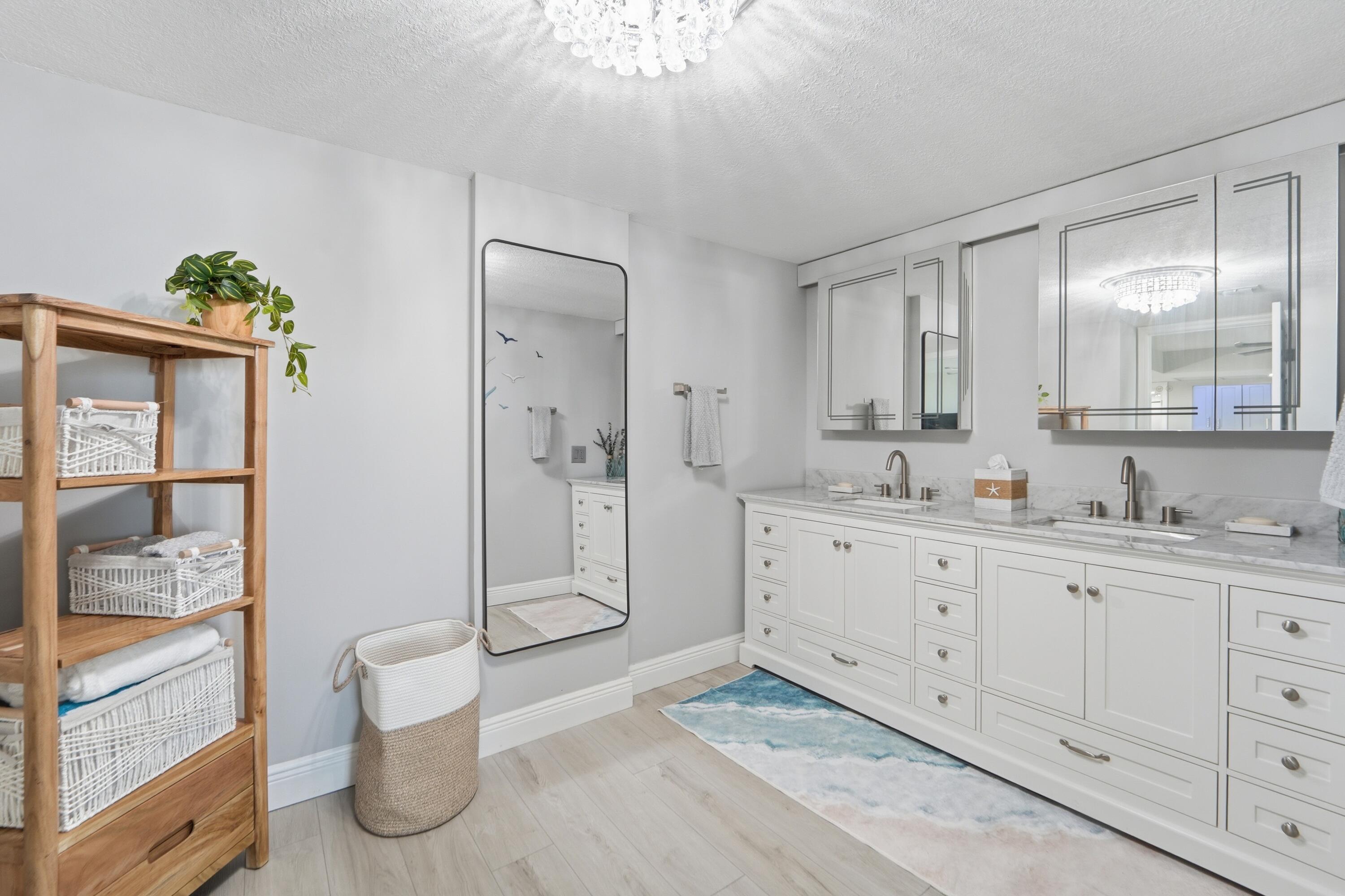 1605 Highway 1, Unit 303M1 Jupiter, FL 33477 - Photo 18 of 42 a spacious bathroom with a double vanity sink a mirror and a shower