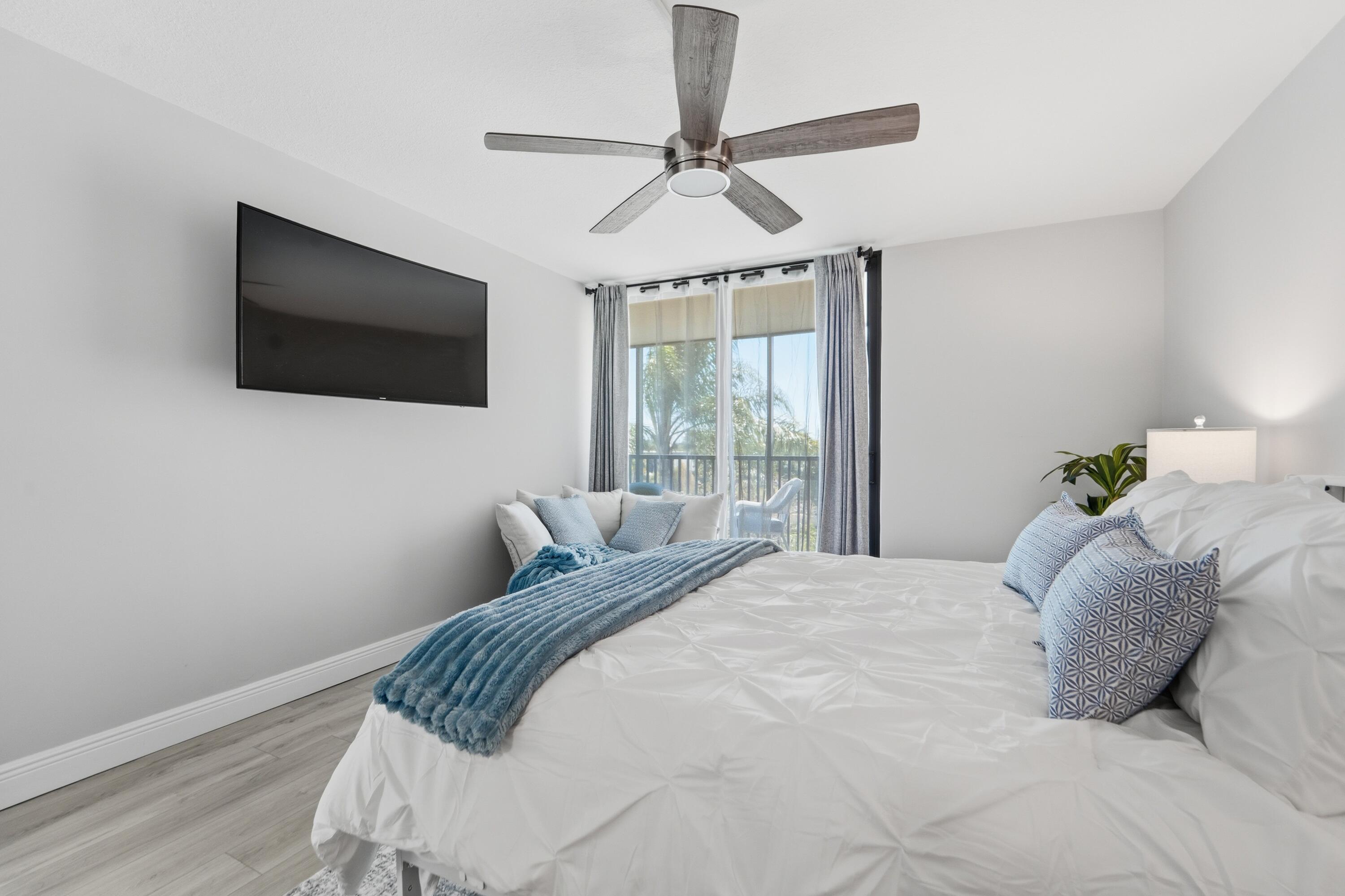 1605 Highway 1, Unit 303M1 Jupiter, FL 33477 - Photo 21 of 42 a bedroom with a large bed and a flat tv screen