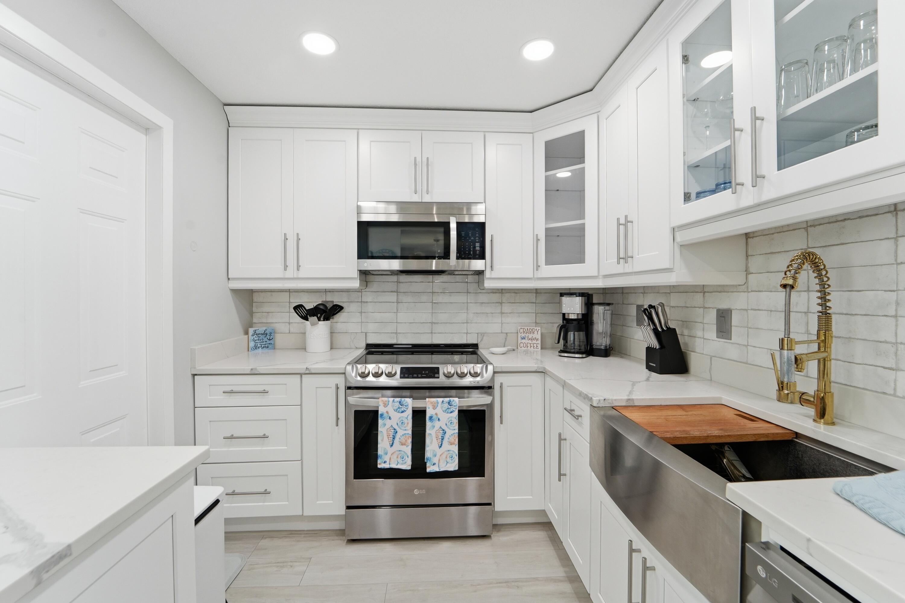 1605 Highway 1, Unit 303M1 Jupiter, FL 33477 - Photo 28 of 42 a kitchen with white cabinets and appliances