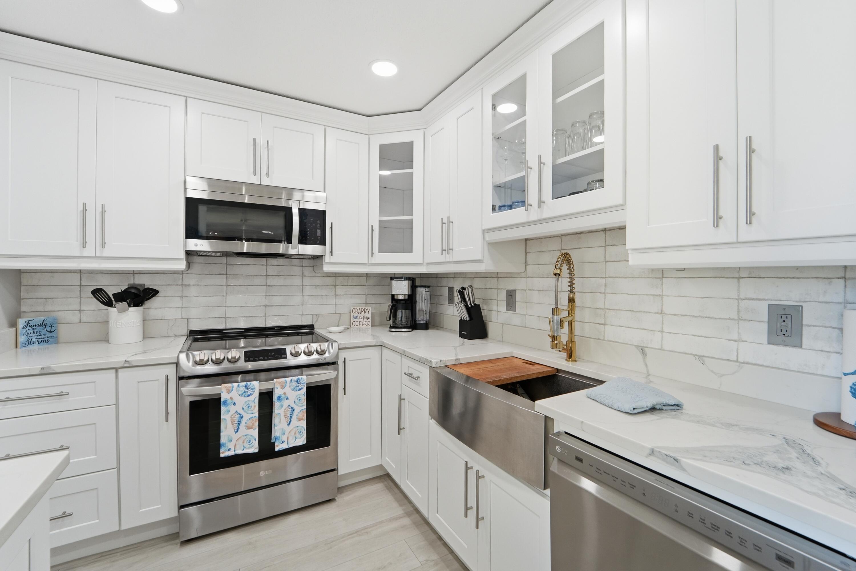 1605 Highway 1, Unit 303M1 Jupiter, FL 33477 - Photo 29 of 42 a kitchen with white cabinets stainless steel appliances and sink