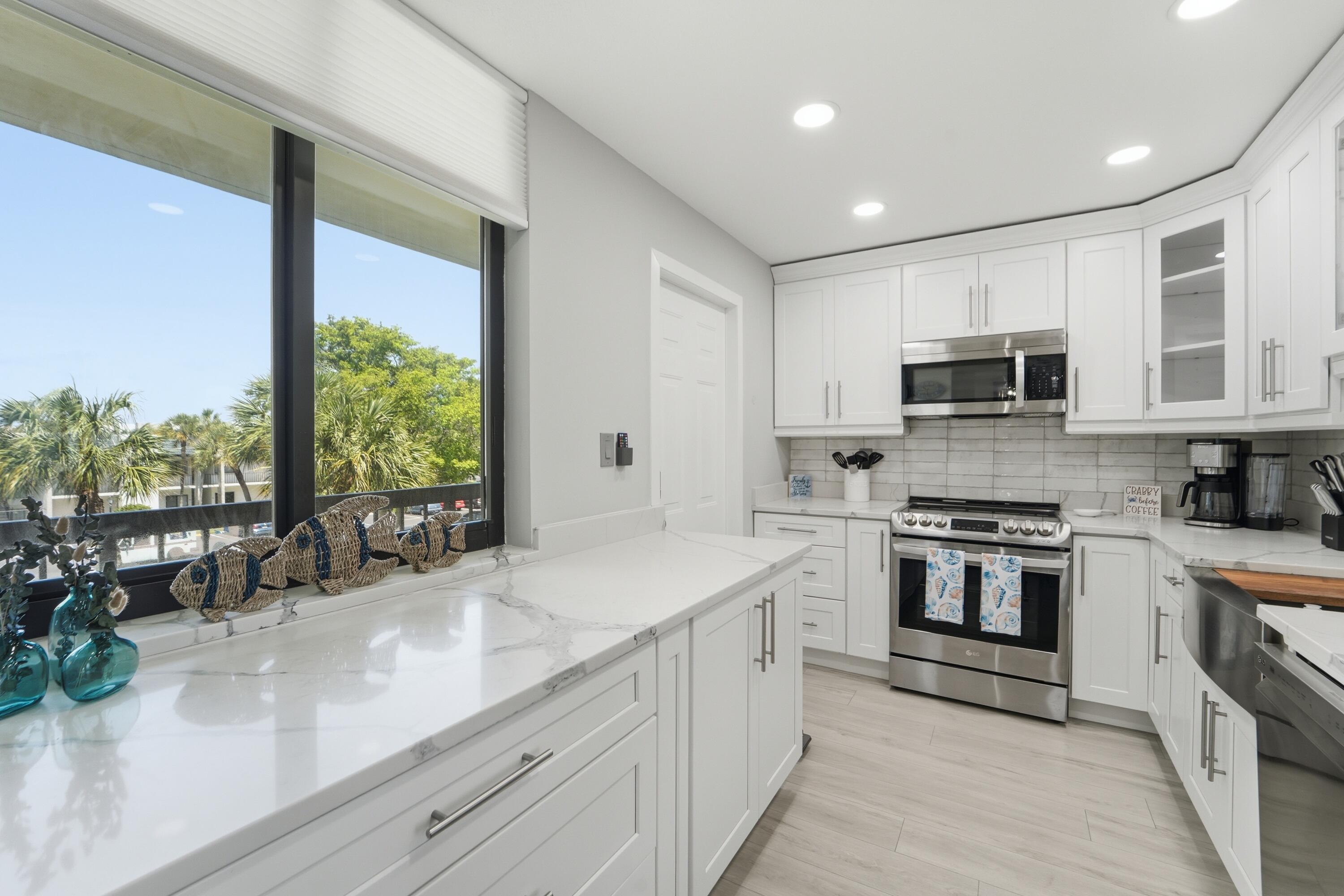1605 Highway 1, Unit 303M1 Jupiter, FL 33477 - Photo 30 of 42 a kitchen with a sink stove and microwave