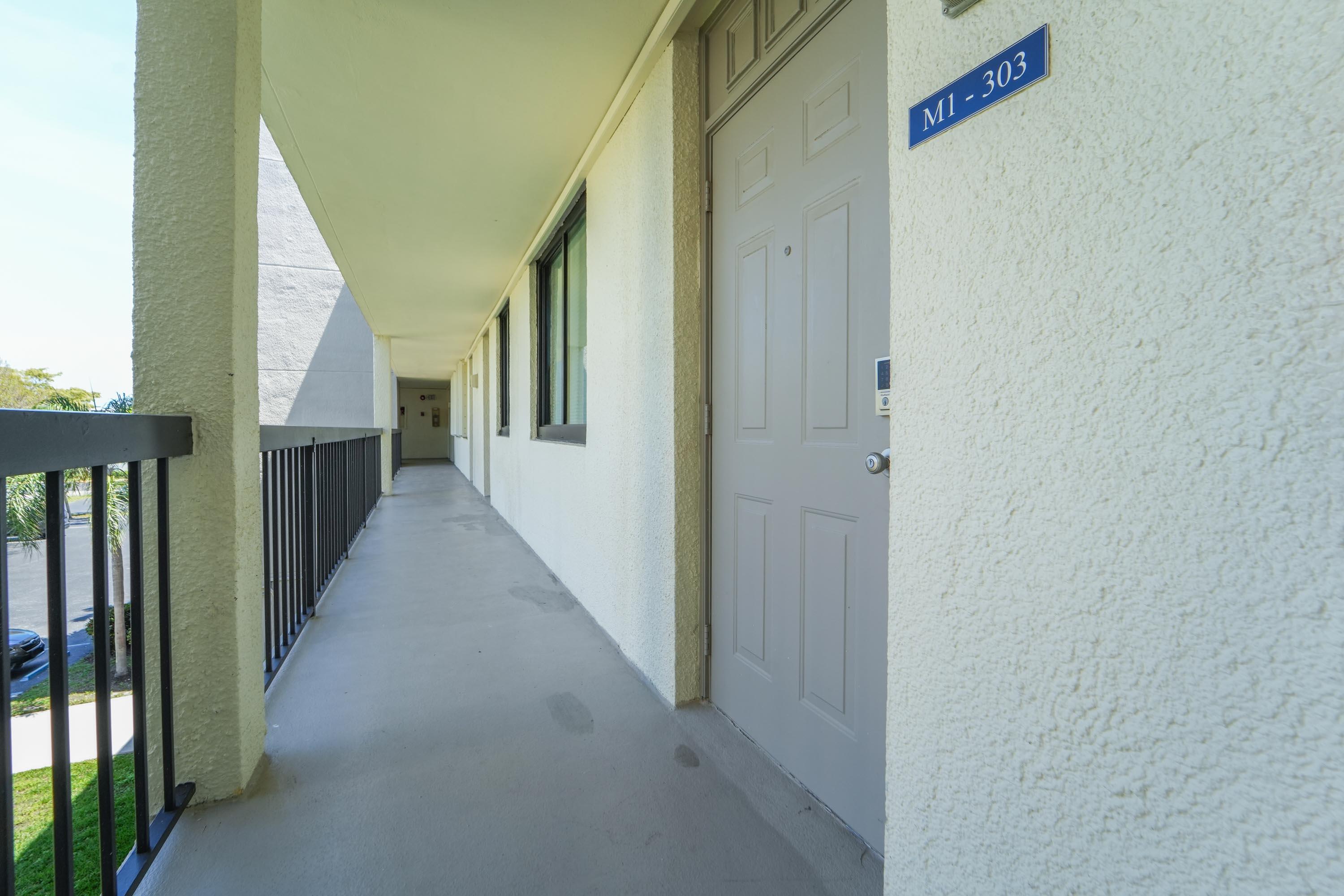 1605 Highway 1, Unit 303M1 Jupiter, FL 33477 - Photo 6 of 42 a view of a hallway with wooden floor and entryway