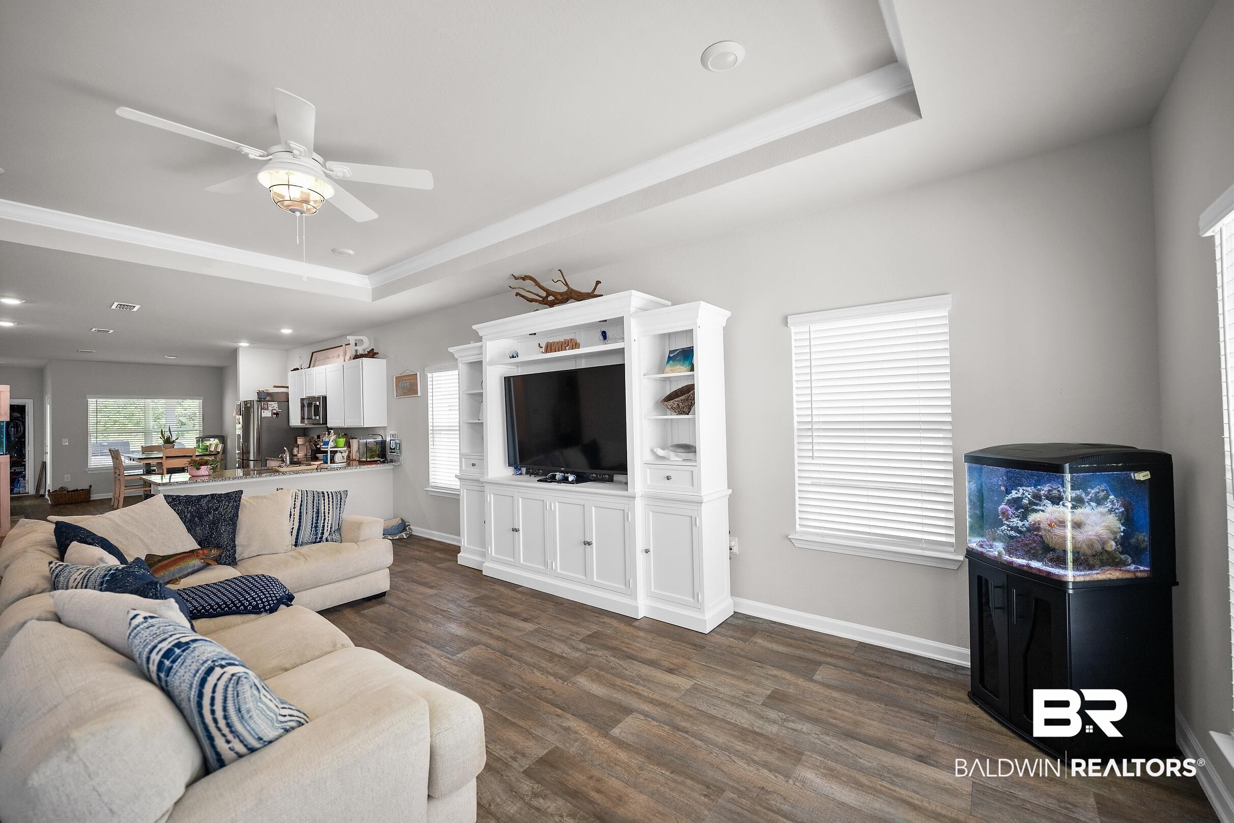 23997 Veranda Circle Elberta, AL 36530 - Photo 3 of 28 Spacious open-concept living area featuring wood-finish flooring, a tray ceiling with a ceiling fan, and light gray walls