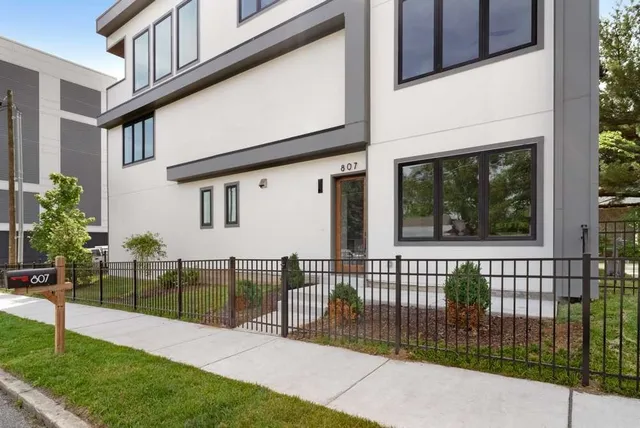 a view of a house with a small yard and wooden fence