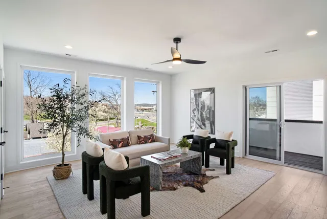 a living room with furniture a window and a potted plant