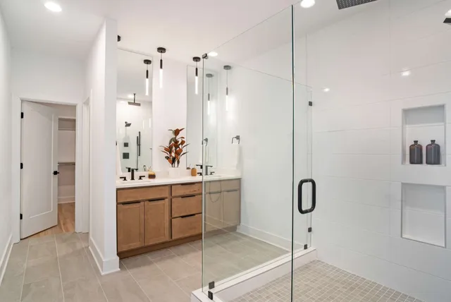 a bathroom with a double vanity sink a mirror a bathtub and shower