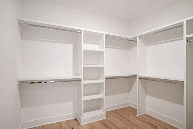 a view of walk in closet with empty racks