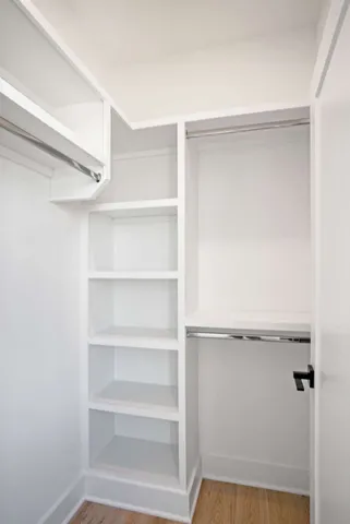 a view of walk in closet with empty racks