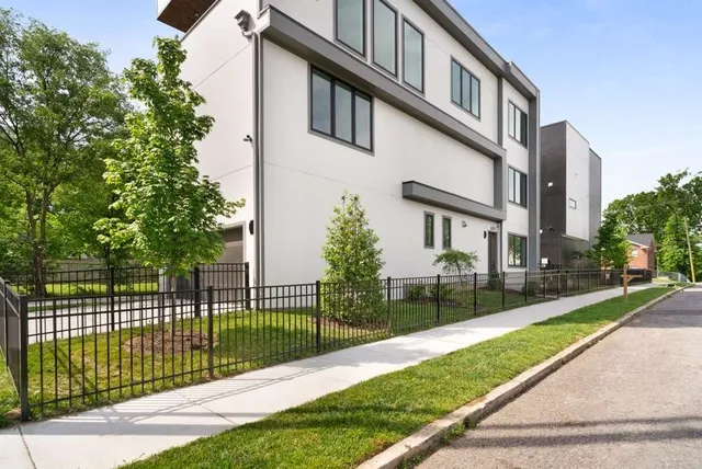 a view of a white building among the tall trees