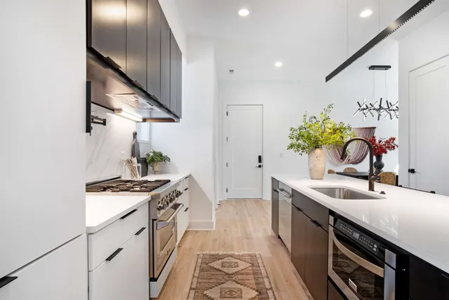 a kitchen with stainless steel appliances a sink stove and cabinets