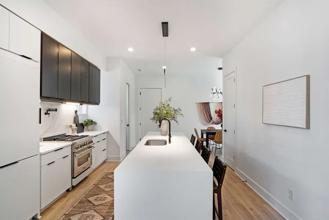 a hallway with a computer on a table and chairs