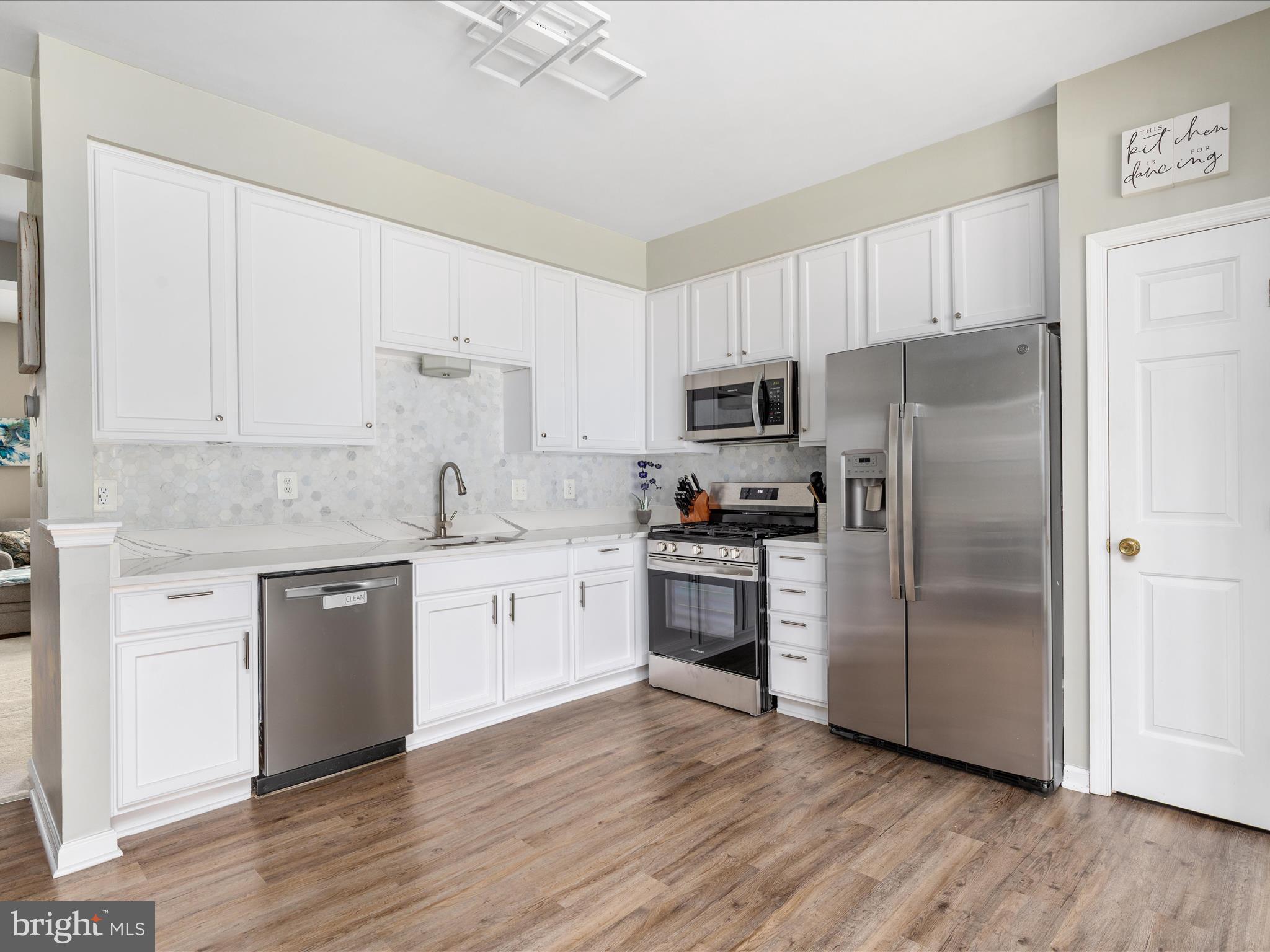 7100 Wheeling Way Gainesville, VA 20155 - Photo 14 of 39 a kitchen with granite countertop white cabinets and stainless steel appliances
