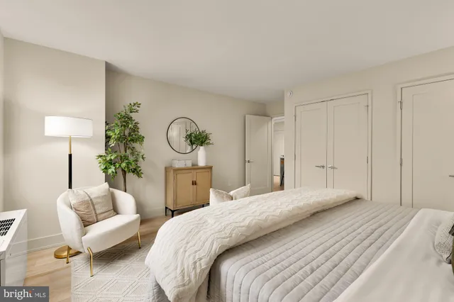 a spacious bedroom with a bed and a lamp