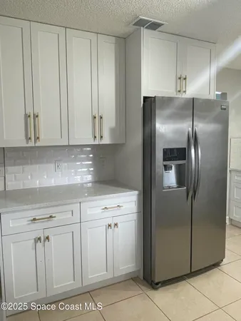 a kitchen with stainless steel appliances granite countertop a refrigerator a stove and cabinets