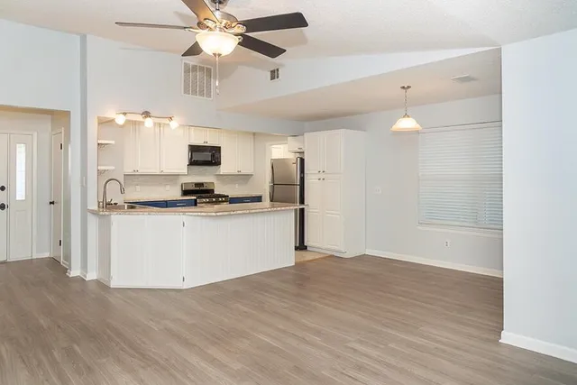 wooden floor fireplace and windows in an empty room