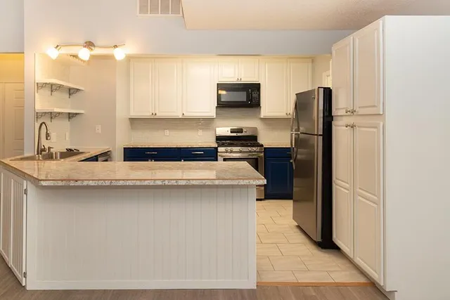 a kitchen with stainless steel appliances granite countertop a refrigerator stove and sink