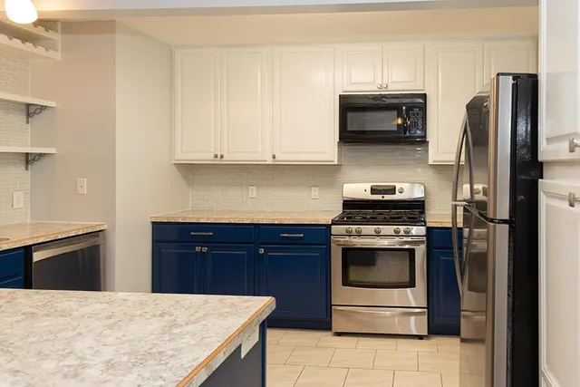 a kitchen with granite countertop white cabinets and appliances