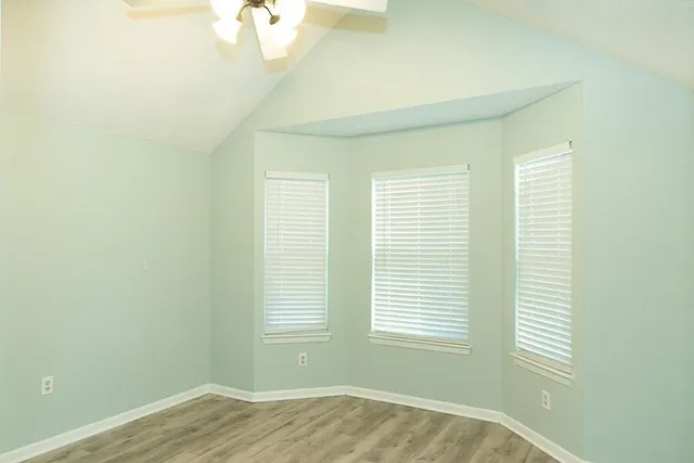 an empty room with a window and a fan